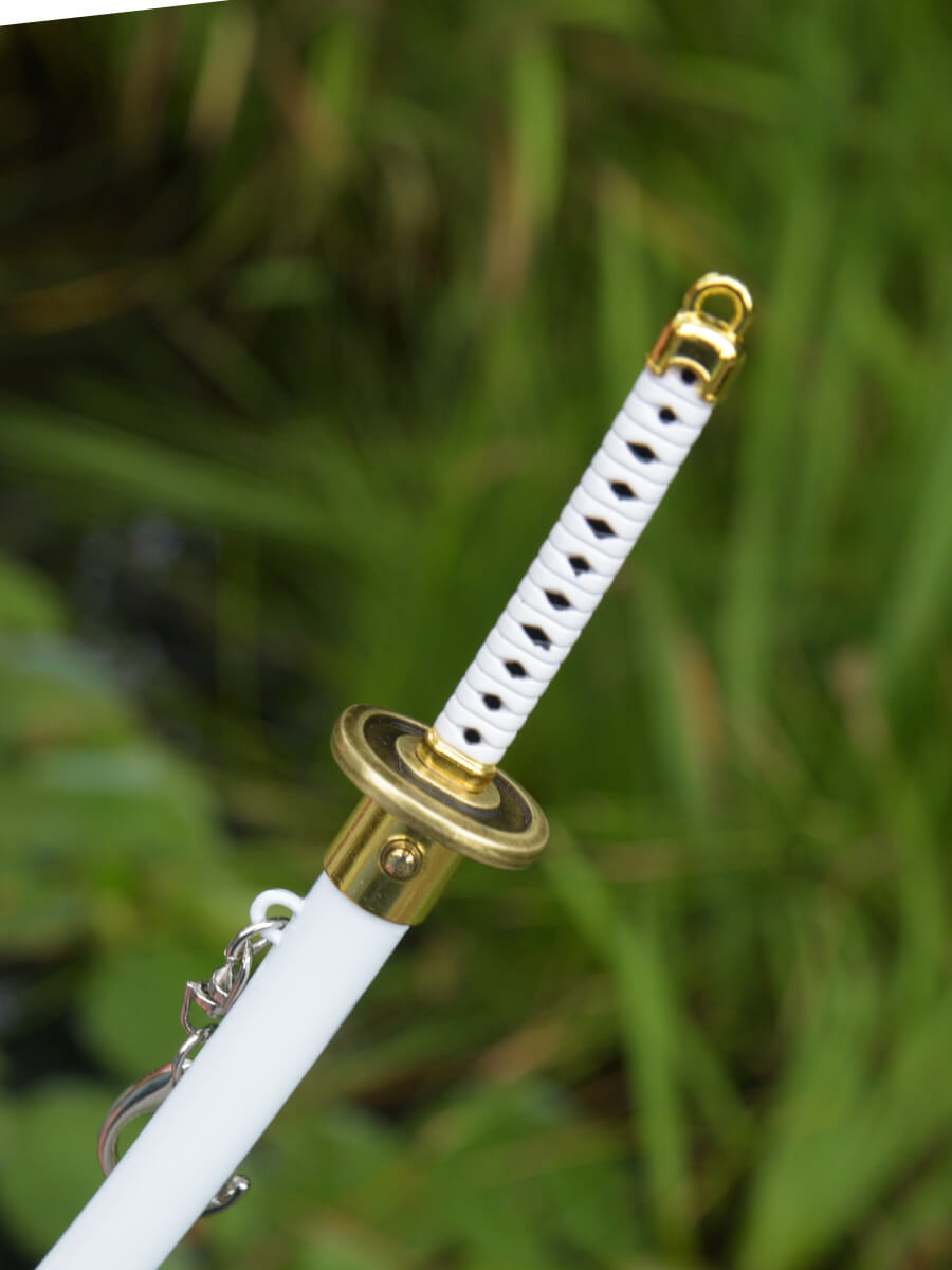 Top angle view of Ichimonji miniature katana handle and part of its sheath showcasing the release button.