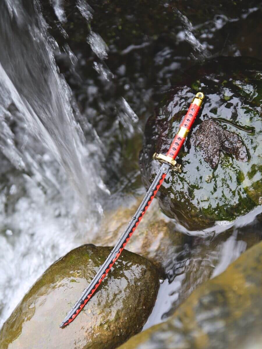 Kitetsu miniature katana from One Piece laid on rocks, drenched with water droplets, resembling a riverbed with a small waterfall in the distance.