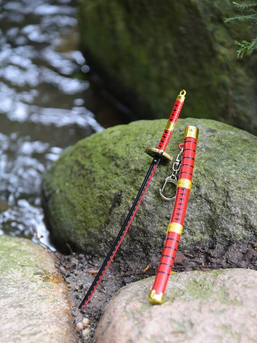 Kitetsu miniature katana without its sheath, resting on a rock surrounded by water - One Piece.