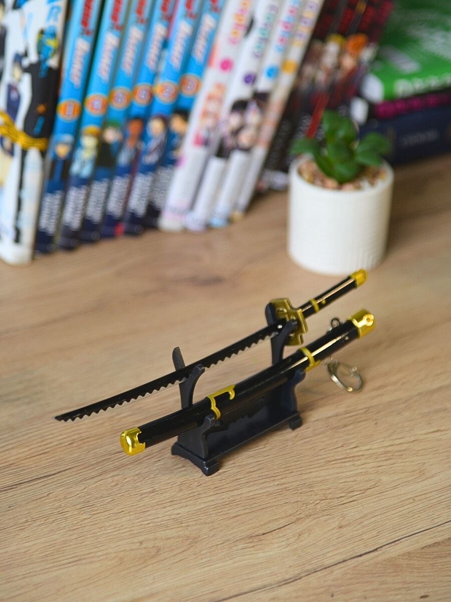 Roronoa Zoro miniature katana, unsheathed and showcased on its stand, bathed in ambient room light with a petite cactus adding to the scene.