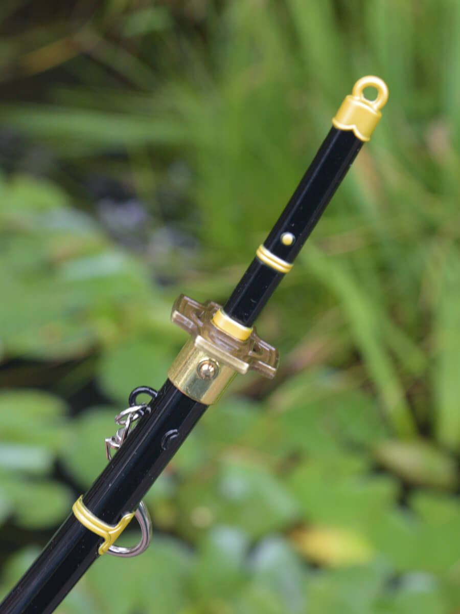 Close-up of Roronoa Zoro miniature katana handle from One Piece, highlighting the release button.