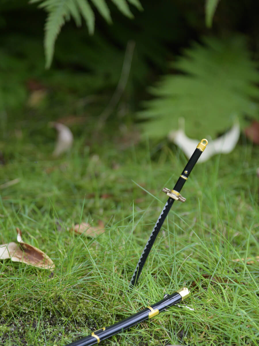 Zoro miniature katana, plunged into the grass with its sheath nearby, capturing a moment of respite.