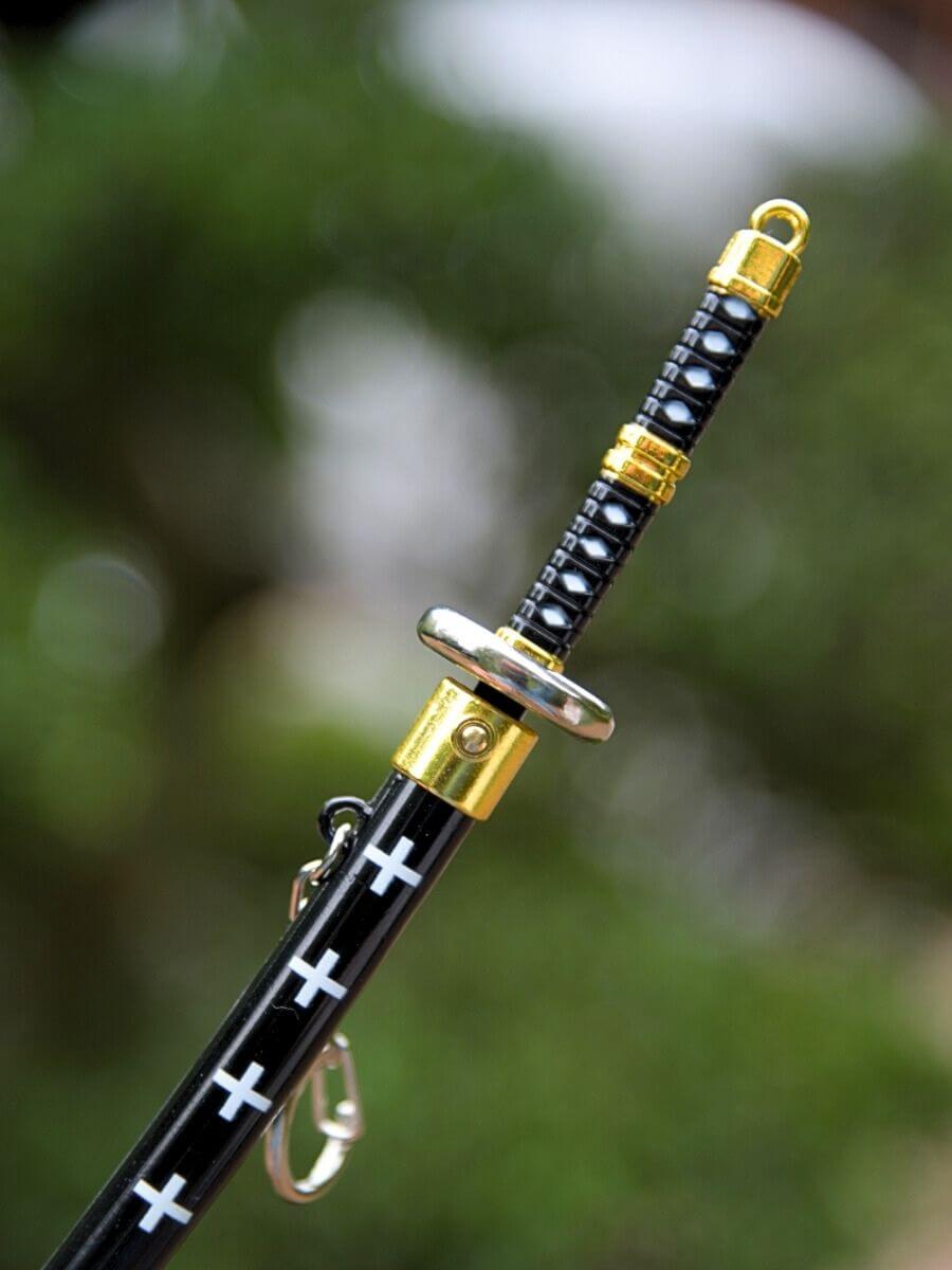 Close-up of Trafalgar miniature katana grip from One Piece, detailing the blade release button.