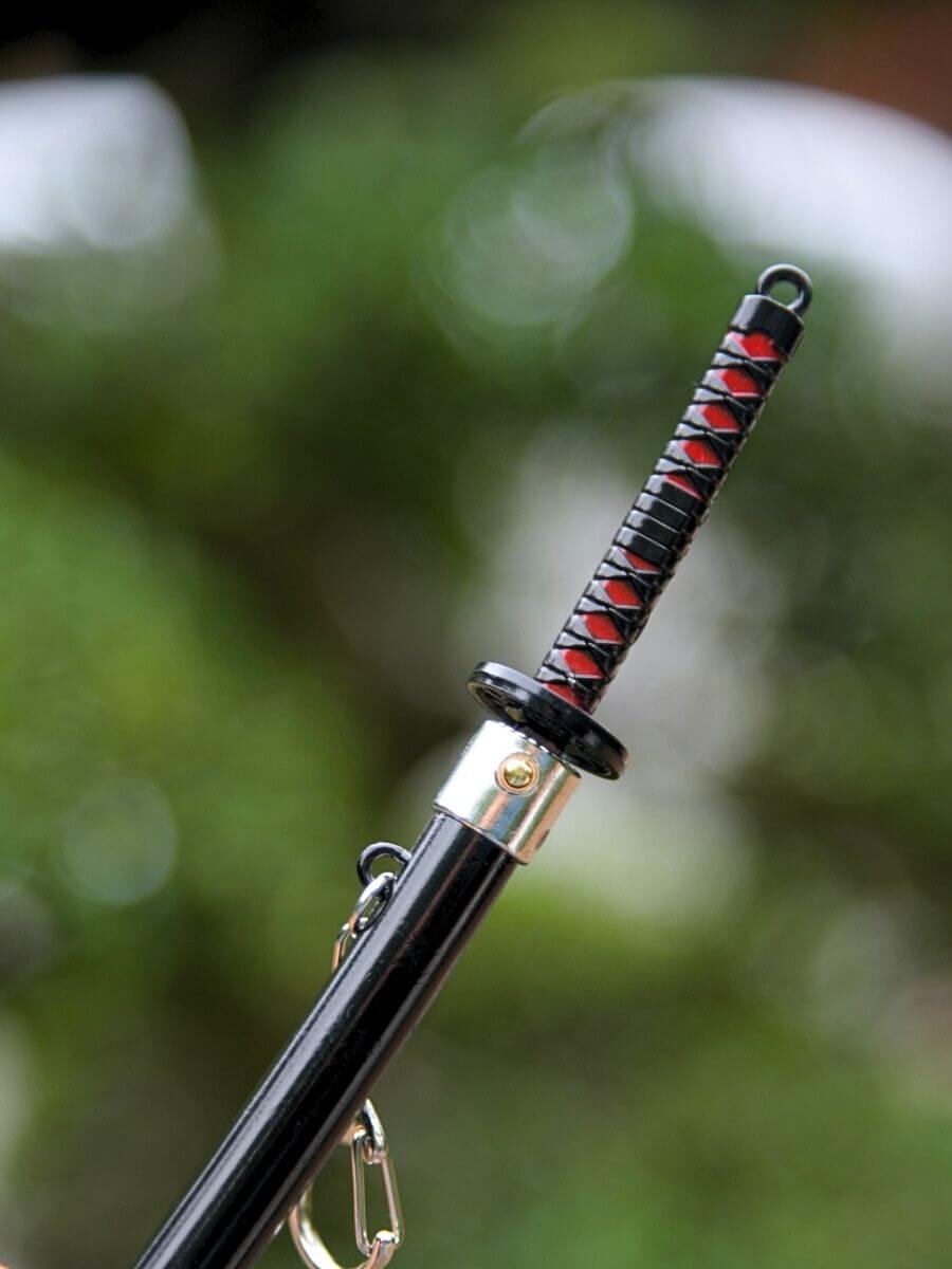 Close-up of Tanjiro miniature katana grip from Demon Slayer, showing the blade release button.